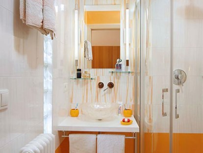 Pensionen - Garten - Die Kombination von weiß und orange finden Sie auch in der modernen sanitären Anlage des orangen Doppelzimmers.   - Residence Sonnengarten**