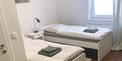 Pensionen - Deutschland - Doppelzimmer mit Einzelbetten, Handtücher und Bettwäsche, Nachttisch - Pension in Emden
