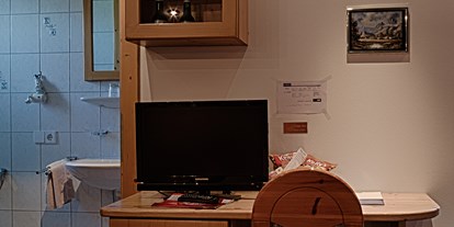 Pensionen - Unken - Einblick ins Bad des Romantikzimmers und Blick auf den Schreibtisch, TV und Minibar unterhalb des Fernsehers.  - Gästehaus Heidi - Ihr Gästehaus mit Herz und Flair