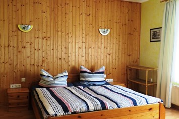 Frühstückspension: Schlafzimmer I mit 3 Betten - Ferienwohnung Kutscherhuus mit Sauna in Ostfriesland