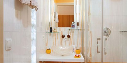 Pensionen - Garten - Schlanders - Die Kombination von weiß und orange finden Sie auch in der modernen sanitären Anlage des orangen Doppelzimmers.   - Residence Sonnengarten**