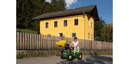 Pensionen - Spielplatz - Zanaischg - Traktorfahren will geübt sein - Haus Brunner - Ferienwohnung im Hühnerhotel