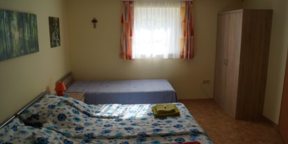 Pensionen - PLZ 2524 (Österreich) - Im Schlafzimmer sind 3 Betten, ein Kasten, 2 Nachtkästchen und ein Tisch mit 2 Stühlen. Ein Babybett kann ebenfalls gemietet werden - ist jedoch mit eigener Bettwäsche zu benutzen. - Appartment Robert