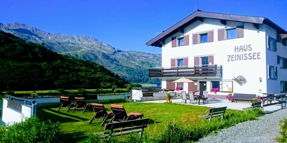 Pensionen - Garten - St. Gallenkirch - Hausansicht mit Liegeweise und Terrasse - im Hintergrund der Zeinissee - Haus Zeinissee