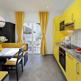 Frühstückspension: Der elegante Wohnbereich mit Küche der gelben Ferienwohnung ist mit allen Annehmlichkeiten ausgestattet.   - Residence Sonnengarten**