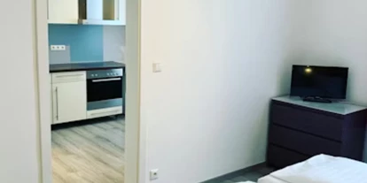 Pensionen - Restaurant - München - Einzimmerapartment -Schlafzimmer mit Übergang in die Küche - Aparthotel & Pension Belo Sono