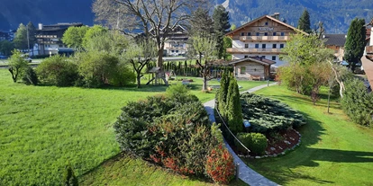 Pensionen - Parkplatz: kostenlos bei der Pension - Alpbach - Der Blick in den Garten vom Birkenhof zum Rosenhof mit der Gartenoase im Herzen des Zillertals. - Hotel Garni Birkenhof & Apartments Rosenhof