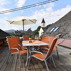 Frühstückspension: Dachterrasse mit Blick auf den Lavamünder Kirchturm - auf die Drau und auf den Marktplatz sowie auf den Berg - Posthostel Lavamünd