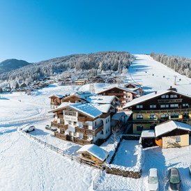 Frühstückspension: Außenansicht im Winter - direkt an der Skipiste beim Achterjet in Flachau - B&B Hotel Die Bergquelle