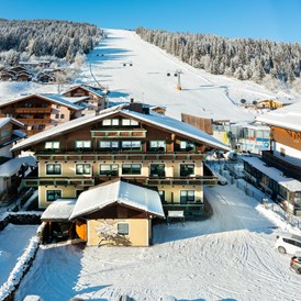 Frühstückspension: Außenansicht im Winter - direkt an der Skipiste beim Achterjet in Flachau - B&B Hotel Die Bergquelle