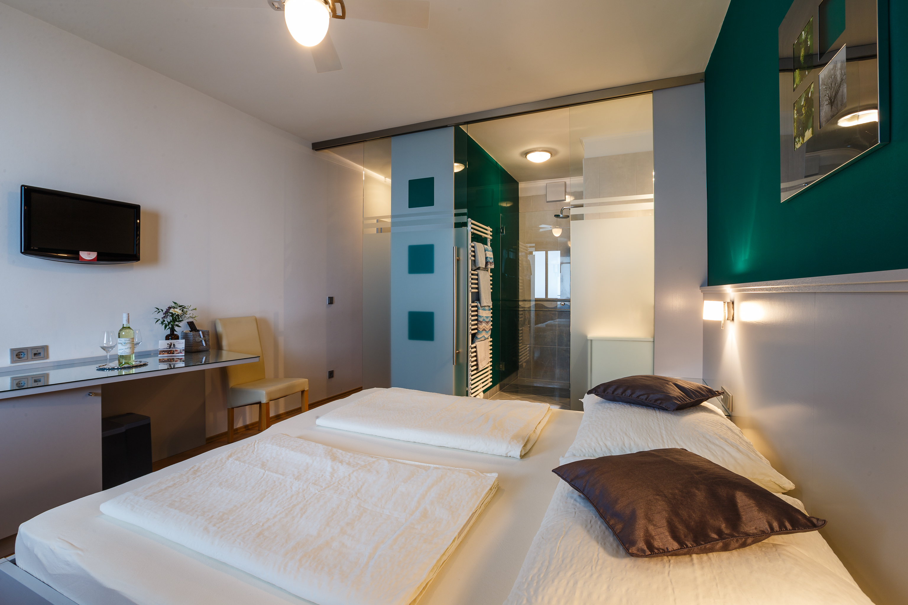 Frühstückspension: Doppelzimmer mit wannenloser Dusche mit Regenbrause, separates WC, Fön, Kosmetikspiegel, Kosmetikartikel, Flachbildschirm mit Kabel TV, Schreibtisch, Zentralheizung, Internetanschluss über Gratis-WLAN, Deckenventilator und Klimaanlage. - Weingut Franz Schindler