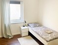 Frühstückspension: Einzelzimmer mit Einzelbett, Bettwäsche, Nachttisch, Lampe - Pension in Emden