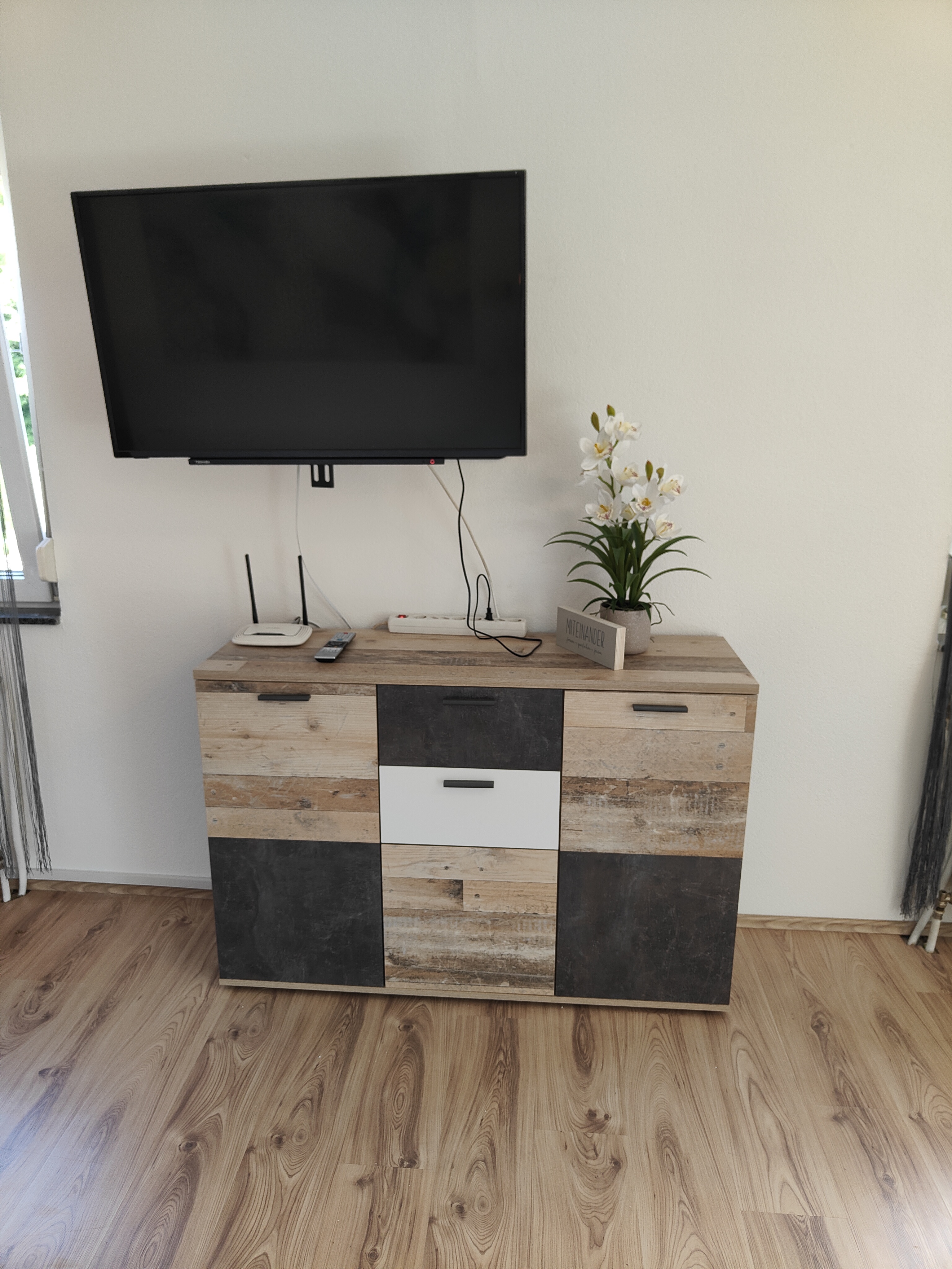 Frühstückspension: schwenkbarer Fernseher nach links oder nach rechts. (links Essplatz, rechts Sofa) - Ferienwohnung Waldblick