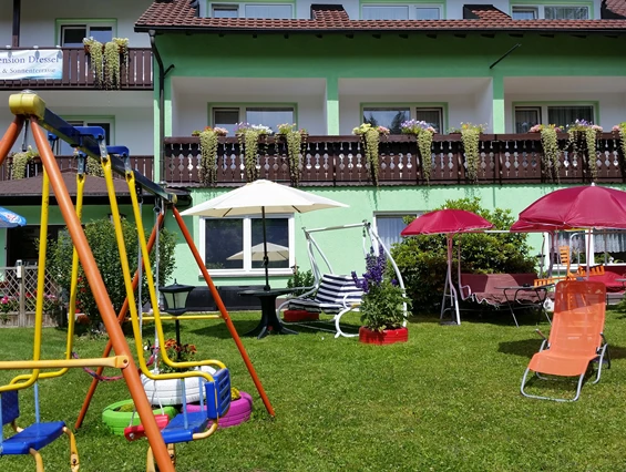 Frühstückspension: Garten mit Kinderschaukel, Sonnenliegen und Hollywoodschaukeln - Gruppenferienhäuser & Hotel-Pension Dressel