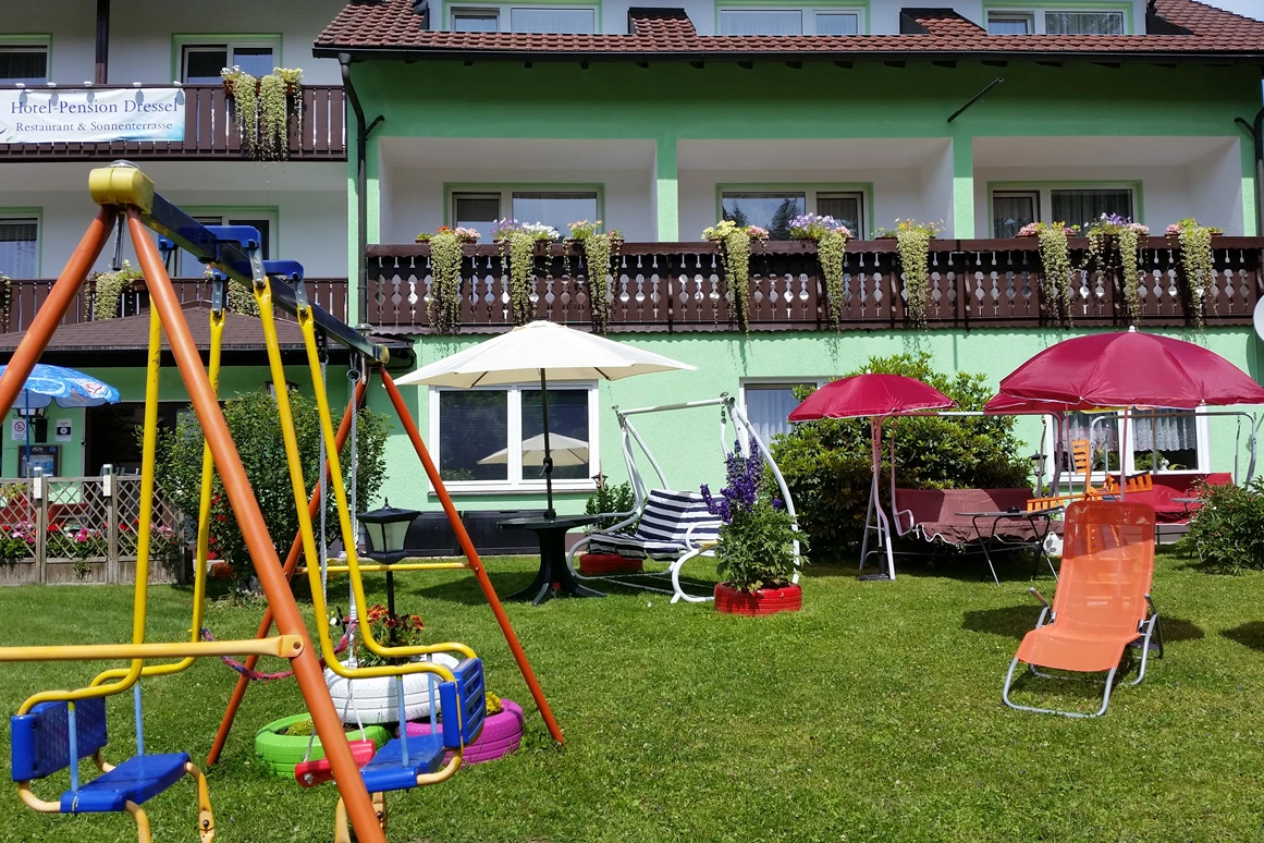 Frühstückspension: Garten mit Kinderschaukel, Sonnenliegen und Hollywoodschaukeln - Gruppenferienhäuser & Hotel-Pension Dressel